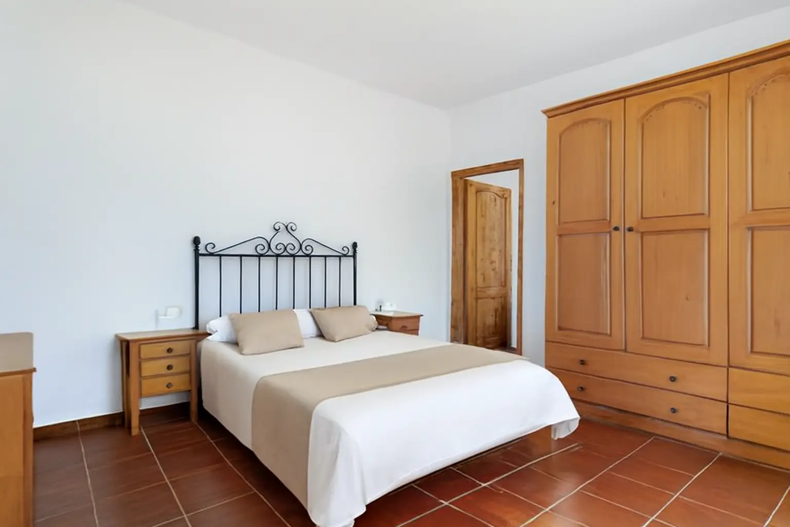 Schlafzimmer mit schmiedeeisernem Bett und großem Kleiderschrank