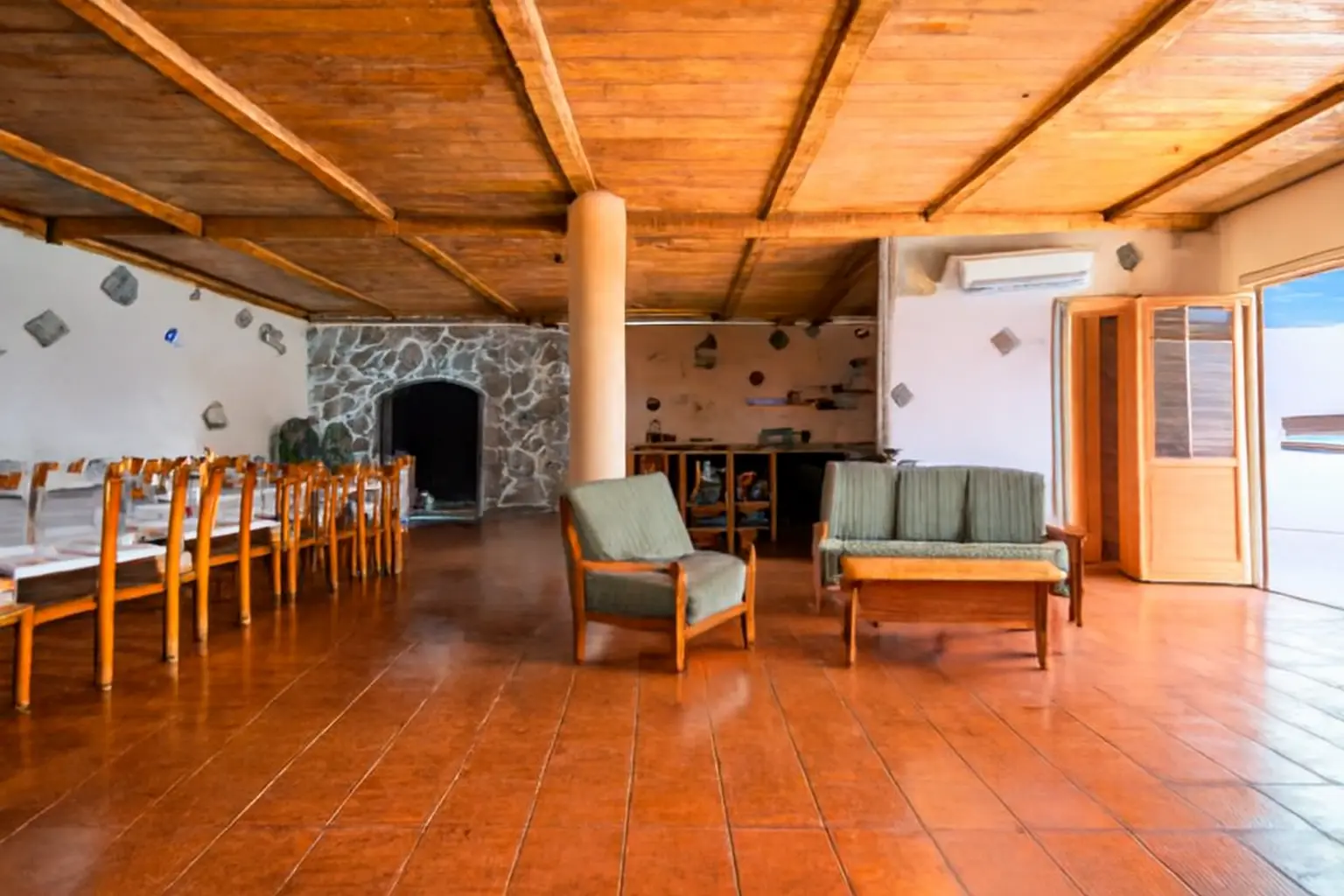 Festsaal mit Steinkamin, Sitzecke und langer Tafel