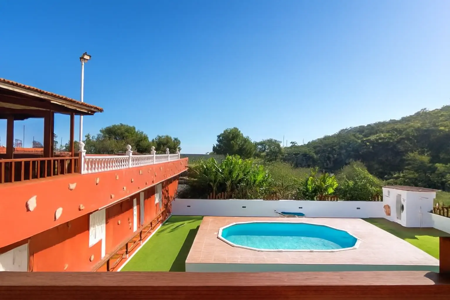 Pool mit Holzdeck, Rasen und Blick in die Natur