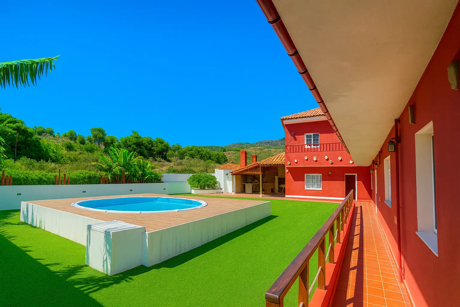 Blick vom Balkon auf Pool, Kunstrasen und Berge