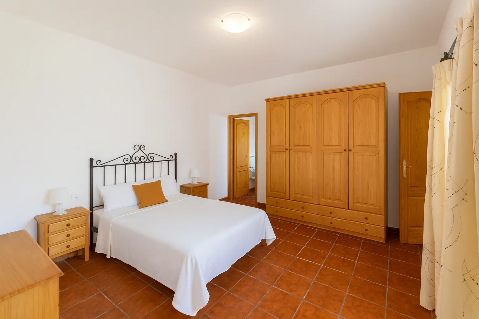 Schlafzimmer mit Doppelbett und Terrakottaboden