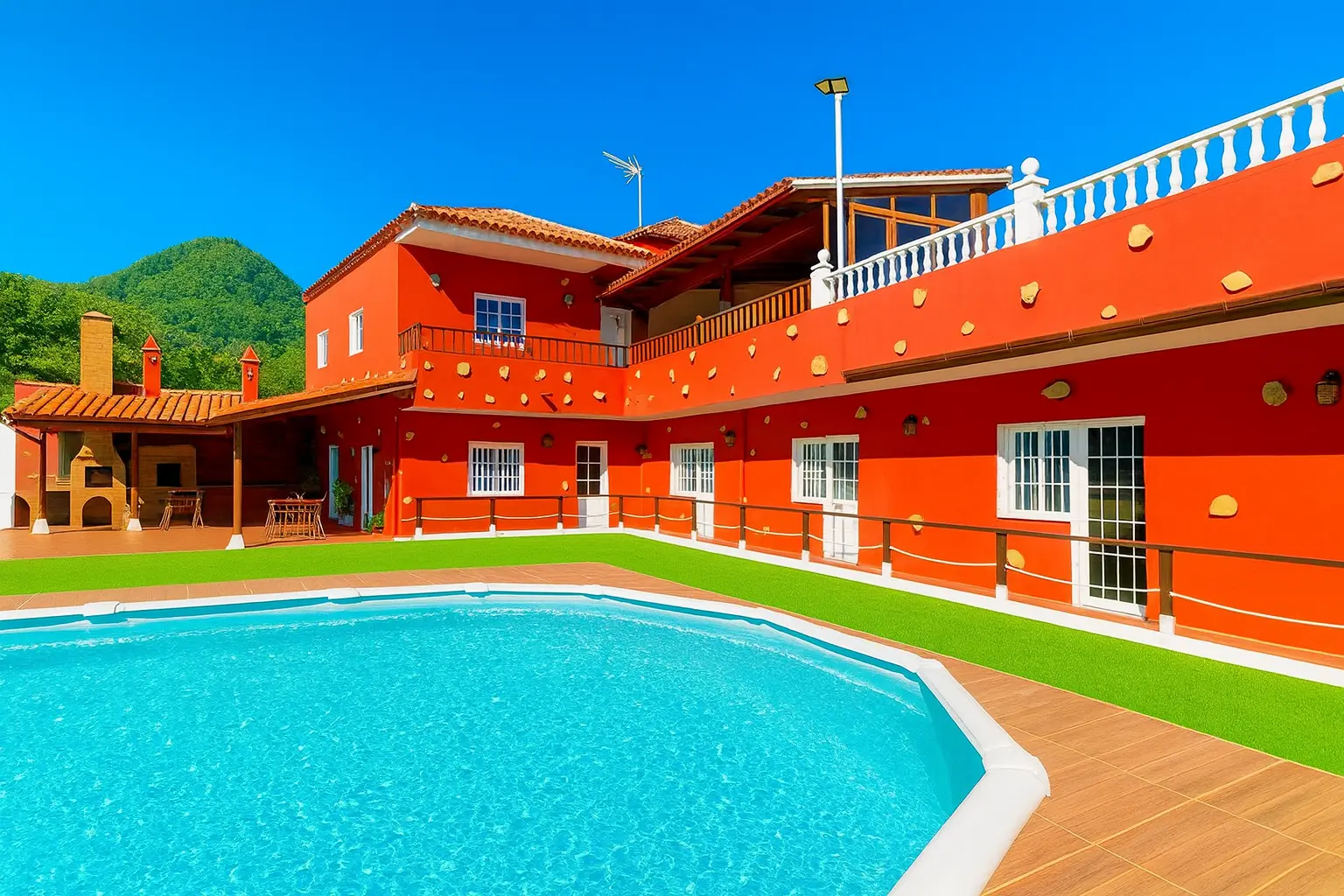 Pool mit Sonnendeck vor dem roten Haupthaus