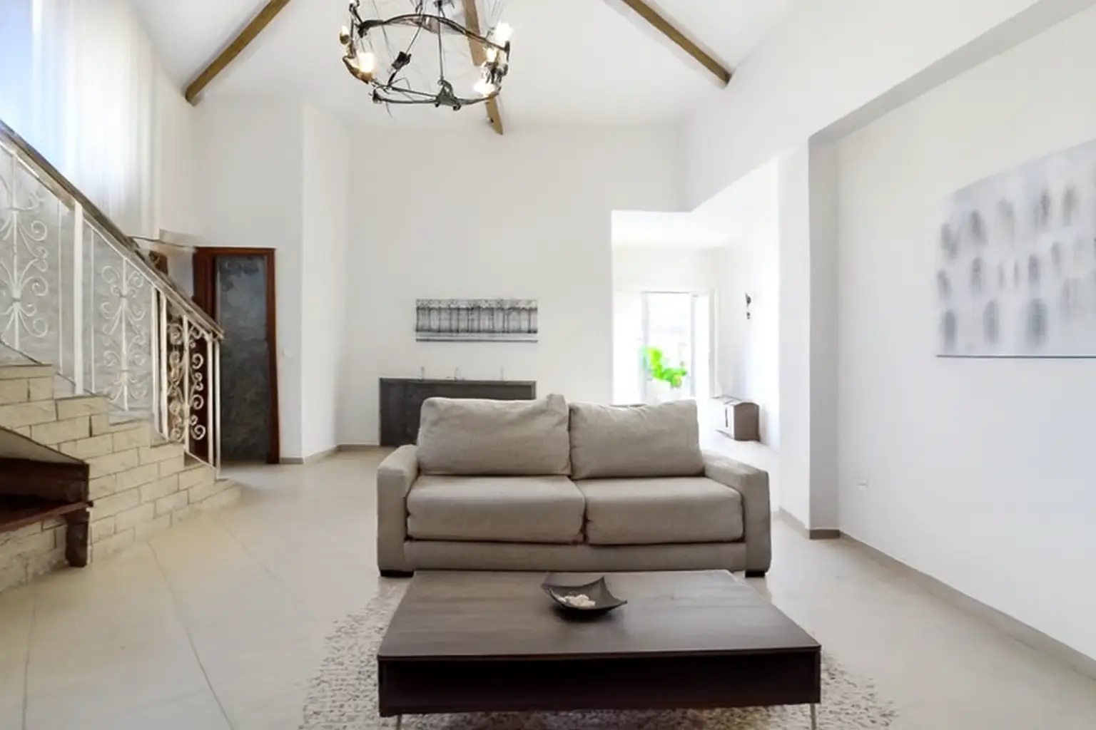 Wohnbereich mit großem Sofa und Blick zur Treppe