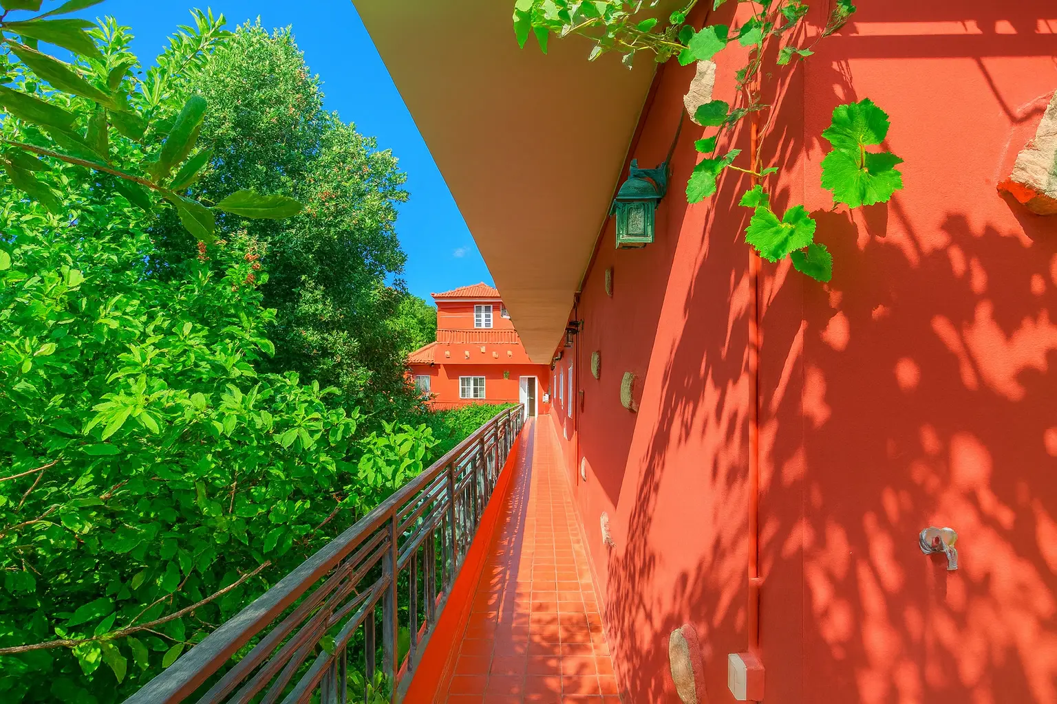 Umlaufender Balkon am roten Haupthaus mit Grünblick