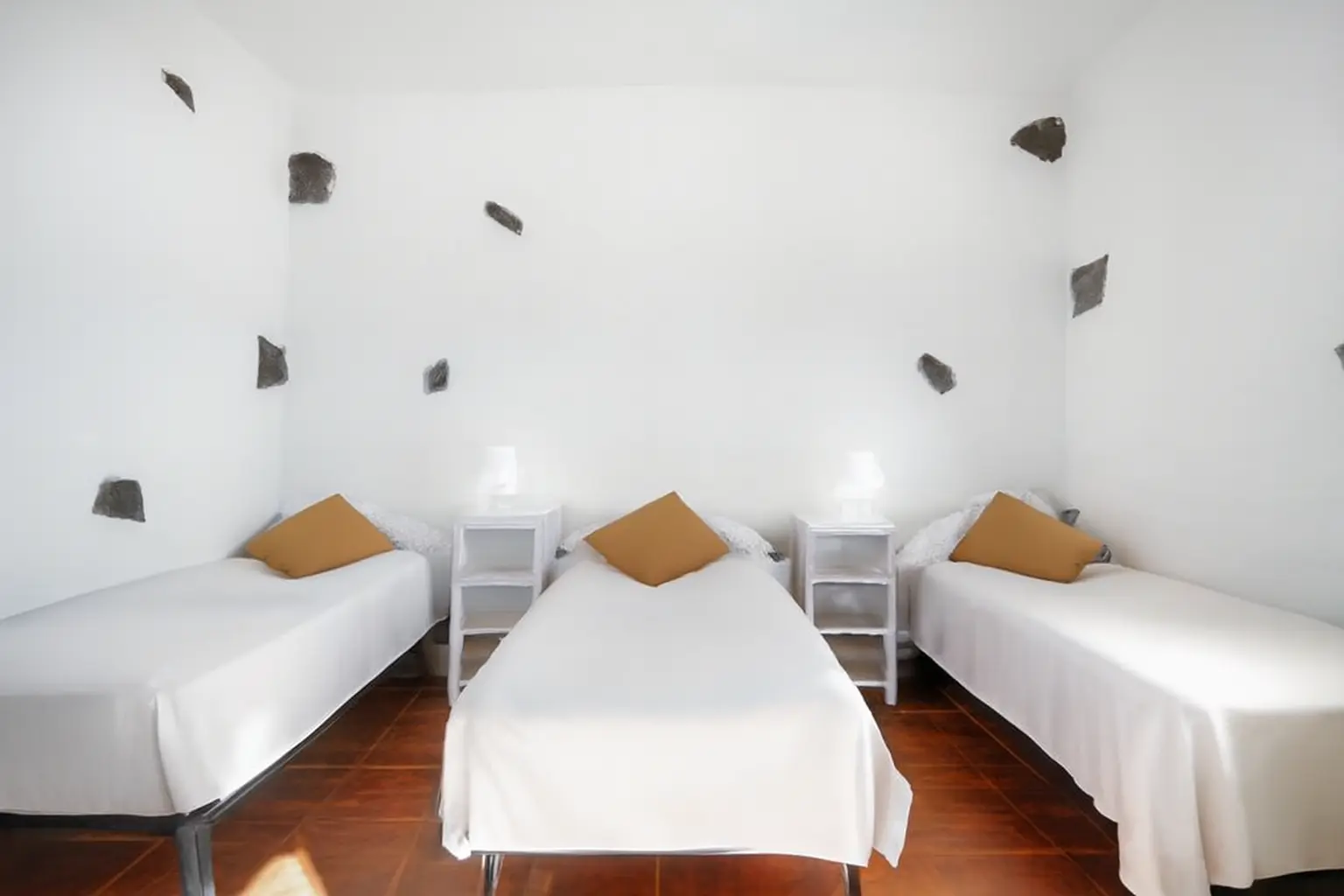 Dreibettzimmer mit Natursteinakzenten an den Wänden