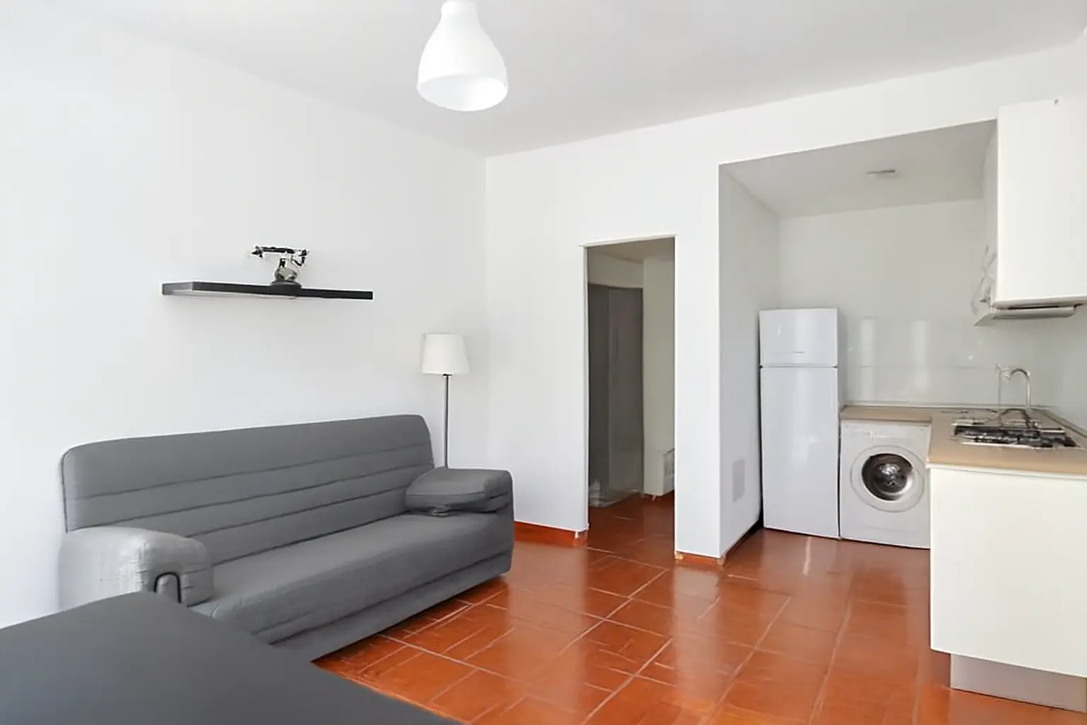 Wohnbereich der Wohnung mit Sofa und offener Küchenzeile